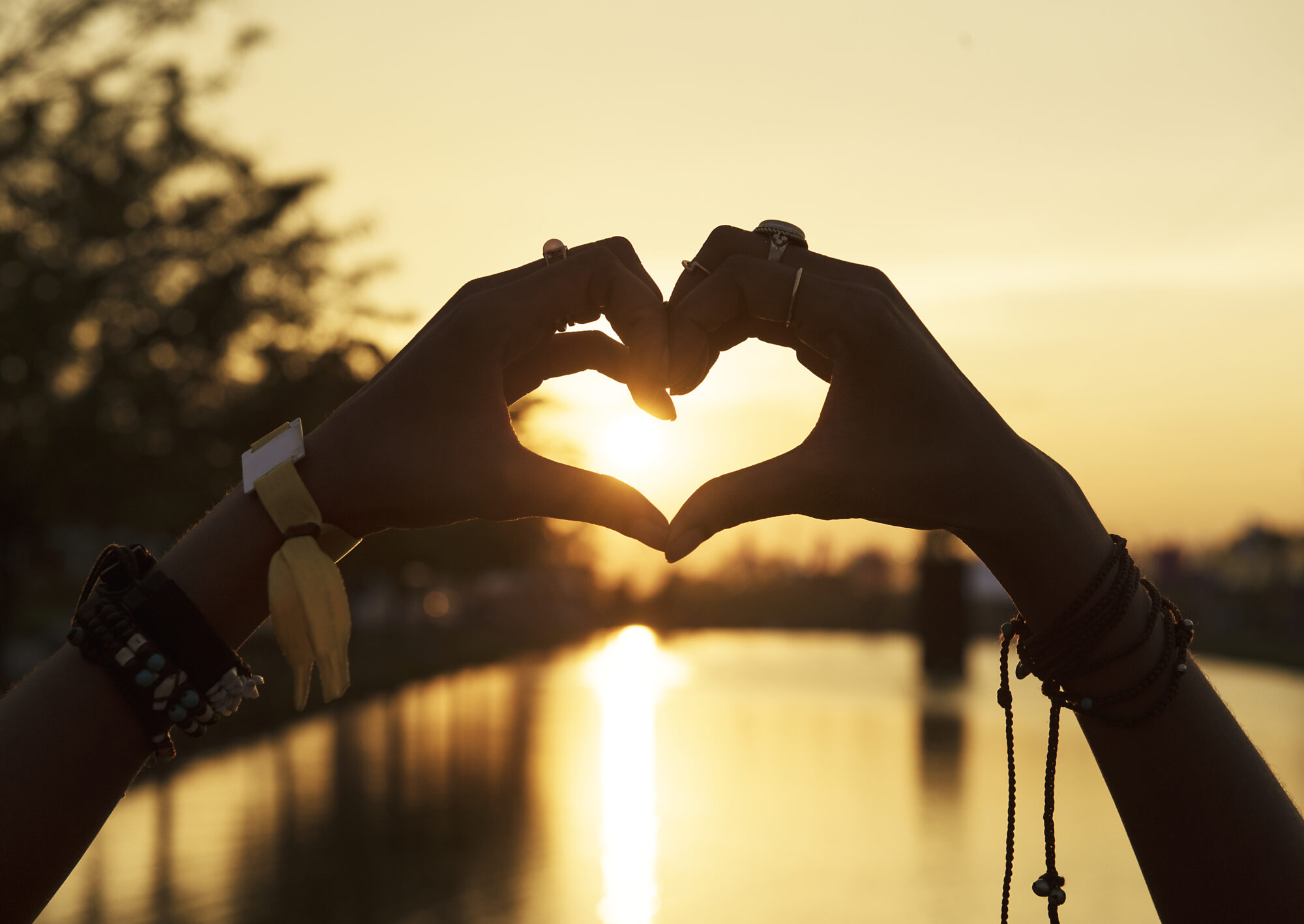 people making hands heart shape silhouette sunset