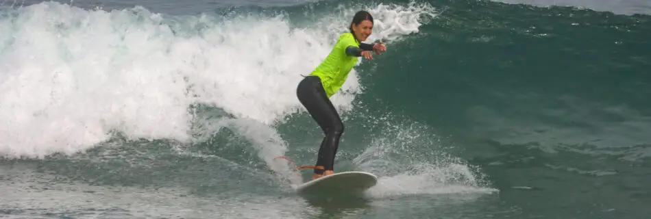 Woman executing perfect surf stance on green wave