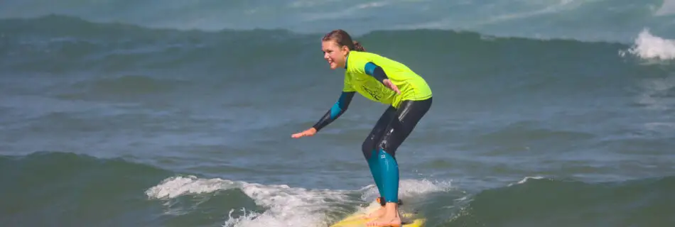 Student trimming across a small green wave