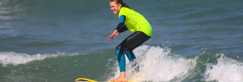 Surfer riding along the face of a turquoise wave