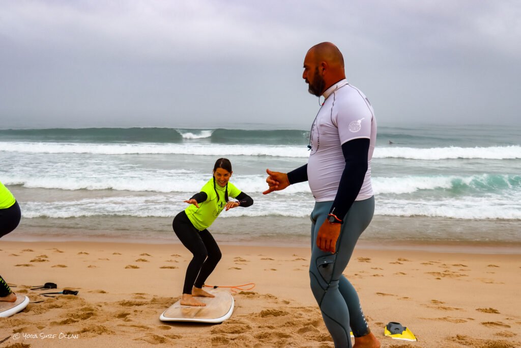 Learn to Surf in Santa Cruz near Lisbon: a Beginner's Guide 1 Luís coaching a young student through the pop-up stance on the beach in Santa Cruz near Lisbon